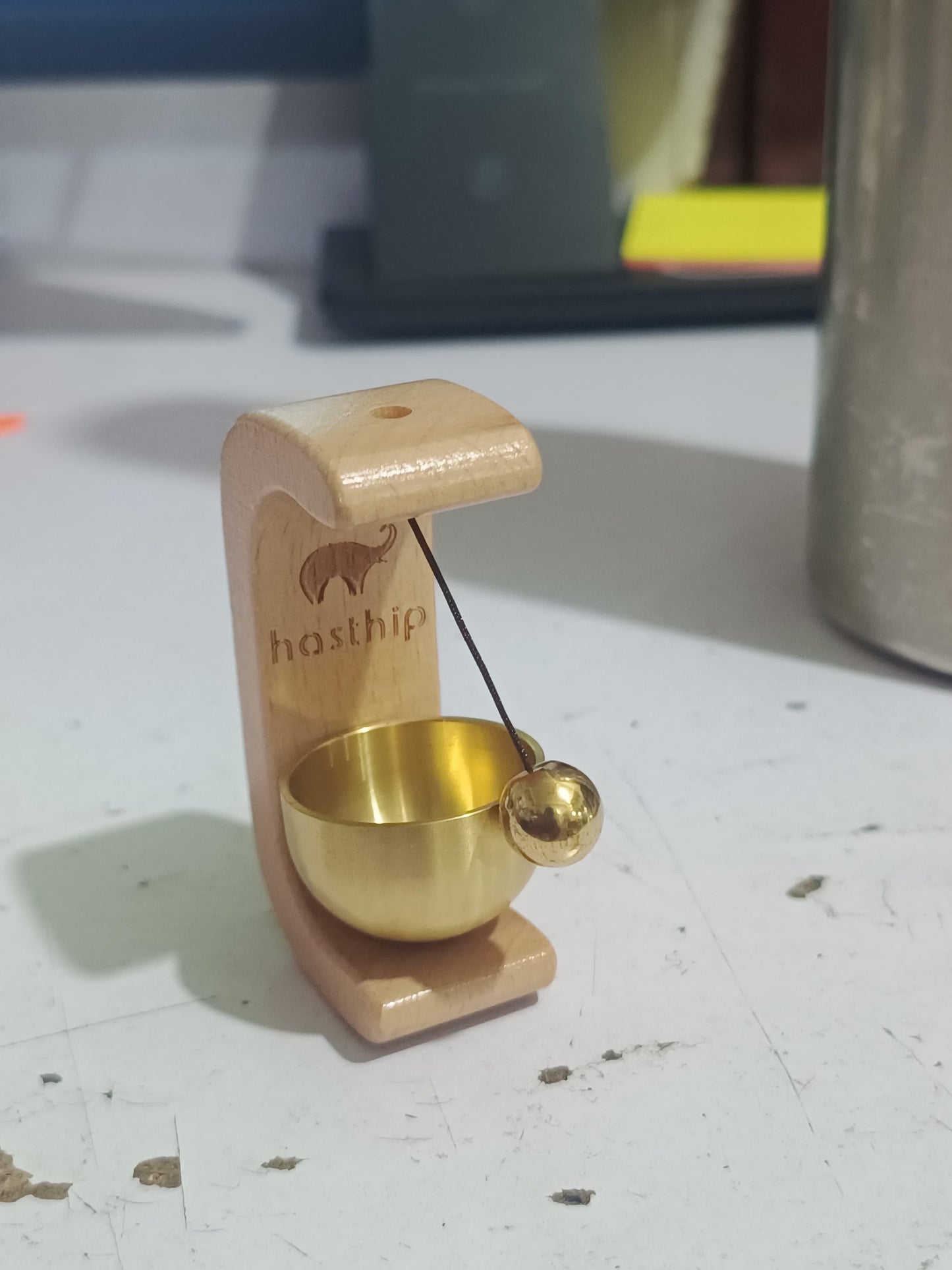 Small wooden and brass object on a white surface
